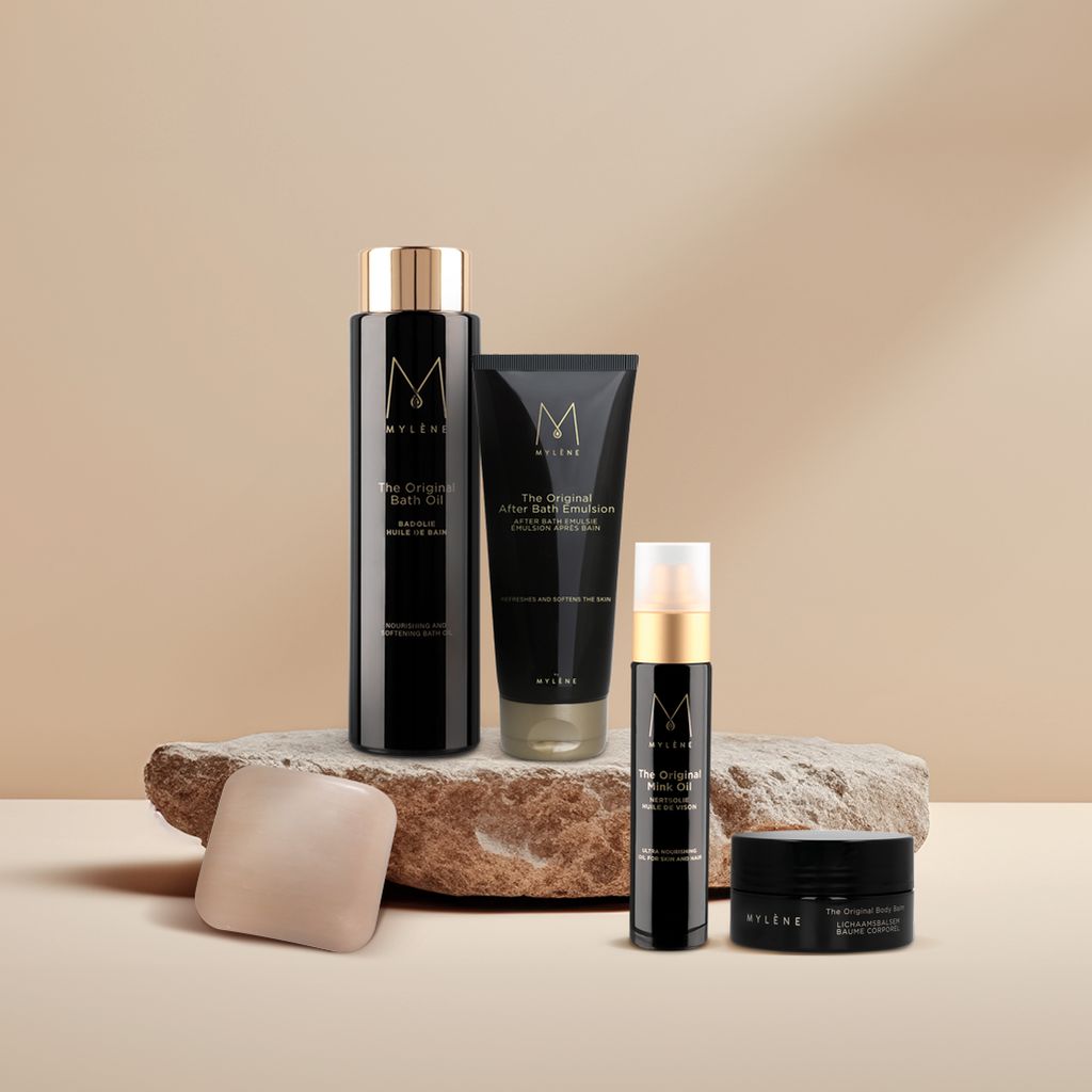 Ensemble de produits sur pierre. Contient: flacon, tube, vaporisateur, pot. Inscription: MYLÈNE, The Original. Différentes tailles et formes.
