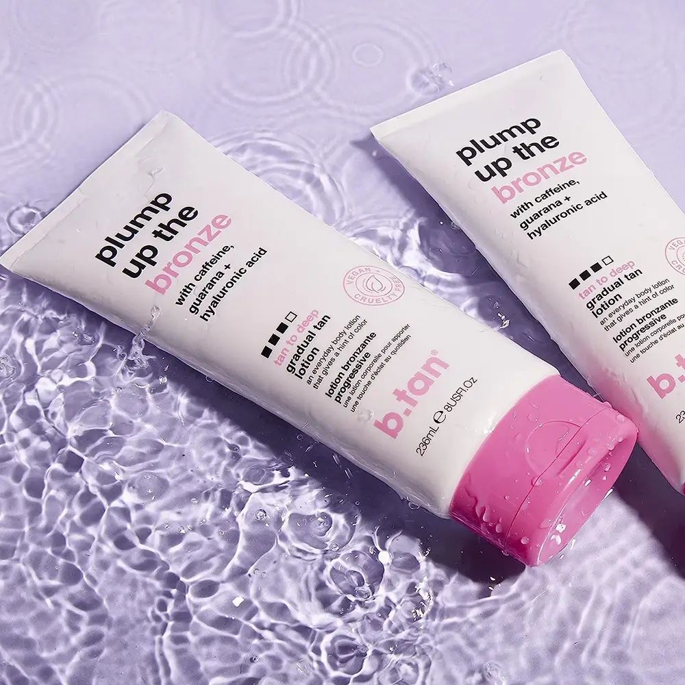 Deux tubes blancs et roses dans l'eau. Inscription : Plump Up the Bronze, tan to deep, b.tan. Label Vegan.