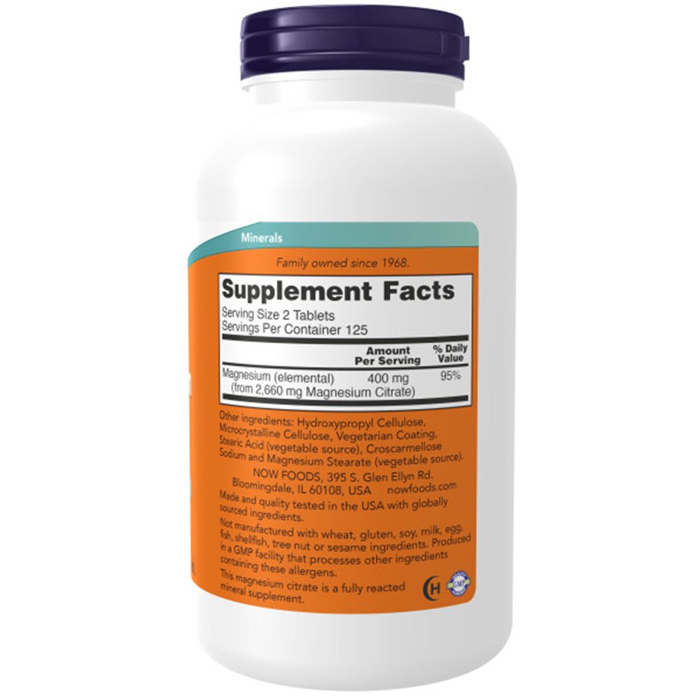 Witte fles met blauwe dop. Oranje etiket met "Supplement Facts" en ingrediënten. "NOW FOODS" logo zichtbaar.