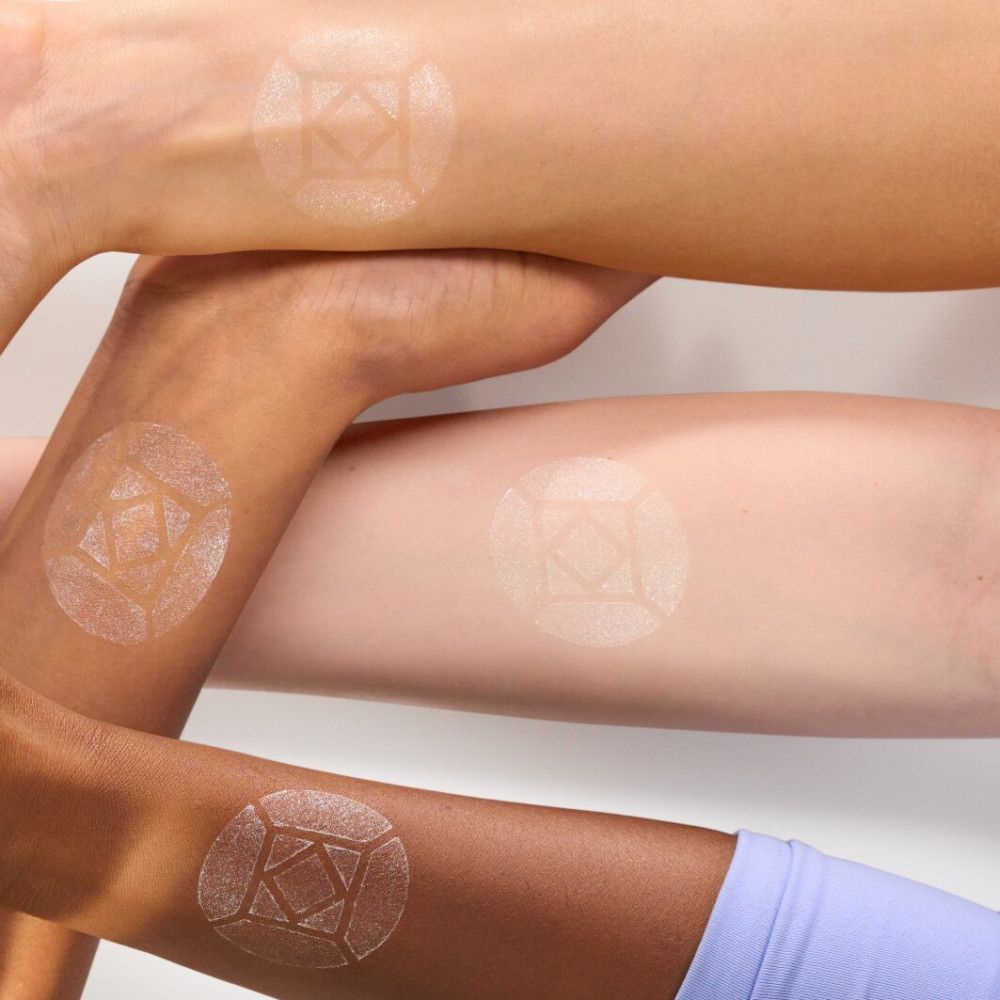 Bras avec test d'highlighter. Appliqué sur différents tons de peau. Forme ronde avec motif géométrique.