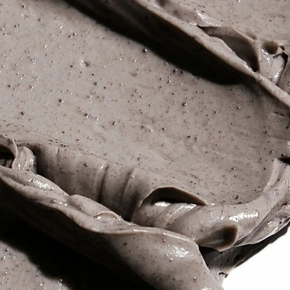 Close-up van een grijs masker. Textuur met kleine zwarte deeltjes.