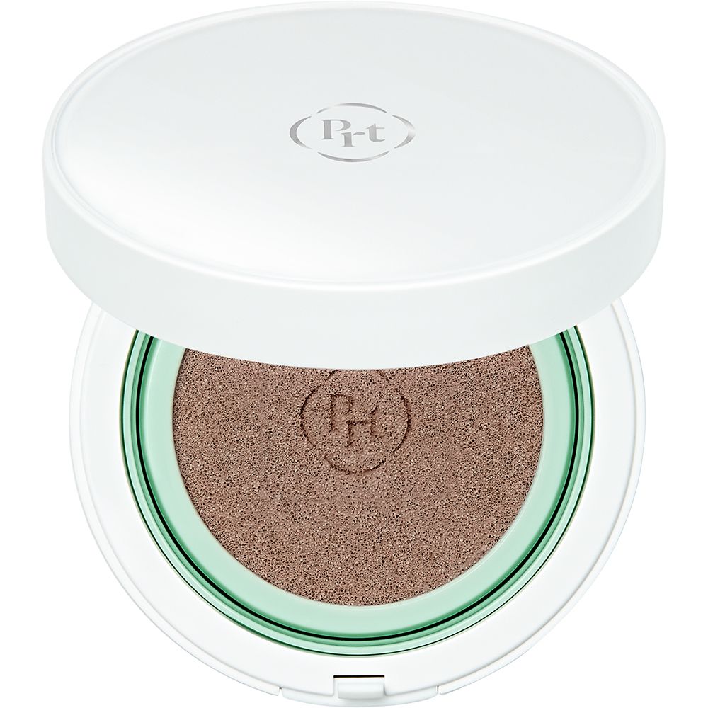 Wit compact make-up doosje, open. Getinte crème, groene rand. Deksel met logo. Bovenaanzicht.