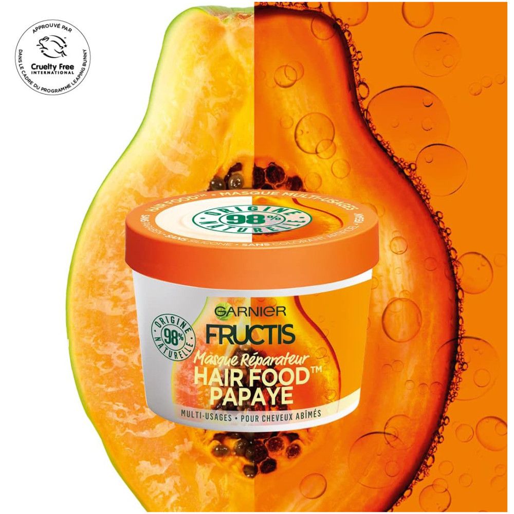 Witte pot met oranje deksel. Opschrift: Garnier Fructis Hair Food Papaye. Achtergrond met afbeelding van een papaya. Cruelty Free label.