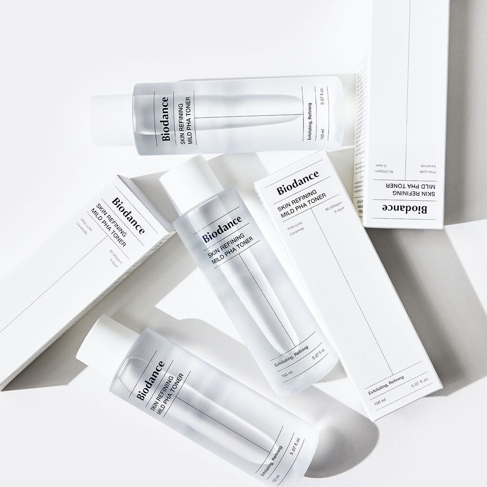 Meerdere flessen en verpakkingen. Opschrift: Biodance Skin Refining Mild PHA Toner. Witte verpakking.