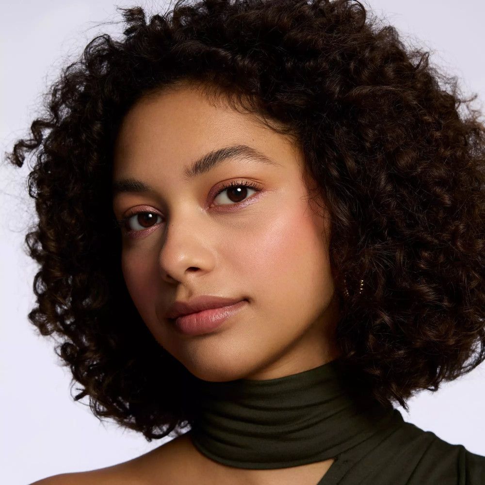 Portrait d'une femme avec fard à paupières rose. Teint, couleur des yeux et des lèvres visibles. Aucune désignation de produit.