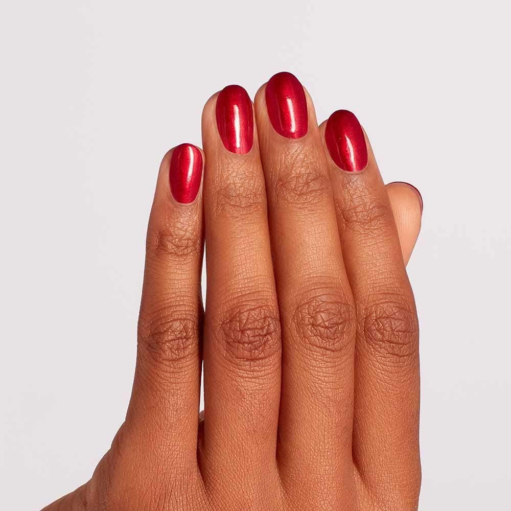 Hand met gelakte nagels. De nagels zijn rood en glanzend.