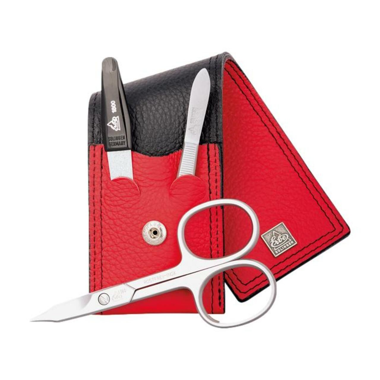 Ensemble de manucure dans un étui en cuir rouge avec ciseaux à ongles, pincettes et coupe-ongles.