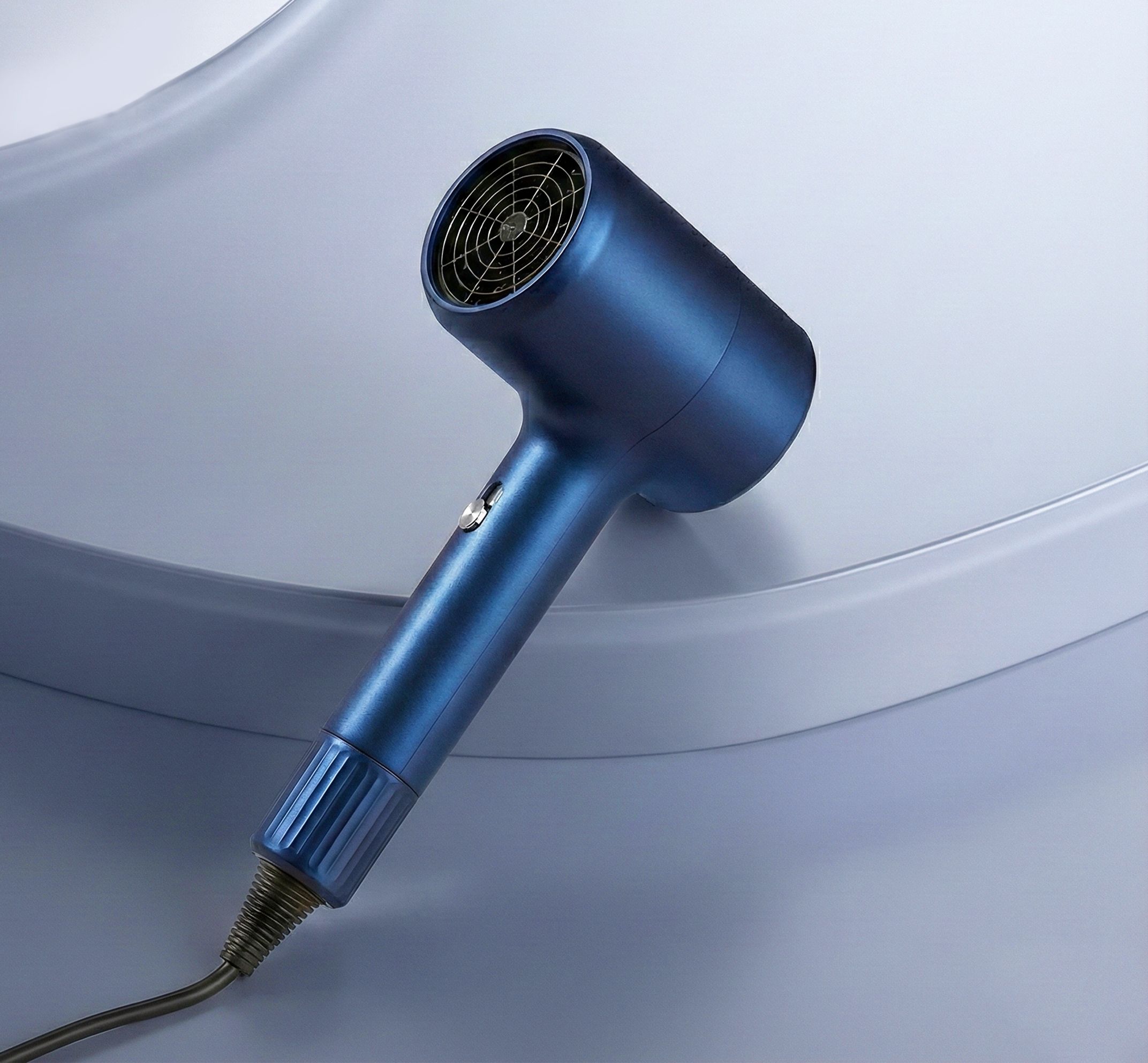 Blauwe haardroger met concentratormondstuk en geribbeld handvat. Ventilatiegrill zichtbaar aan het uiteinde.