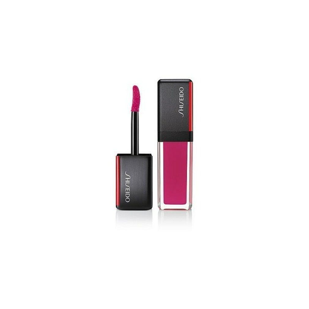 Rouge à lèvres avec capuchon noir et accent rouge. L'applicateur est sorti. Logo Shiseido sur le capuchon.