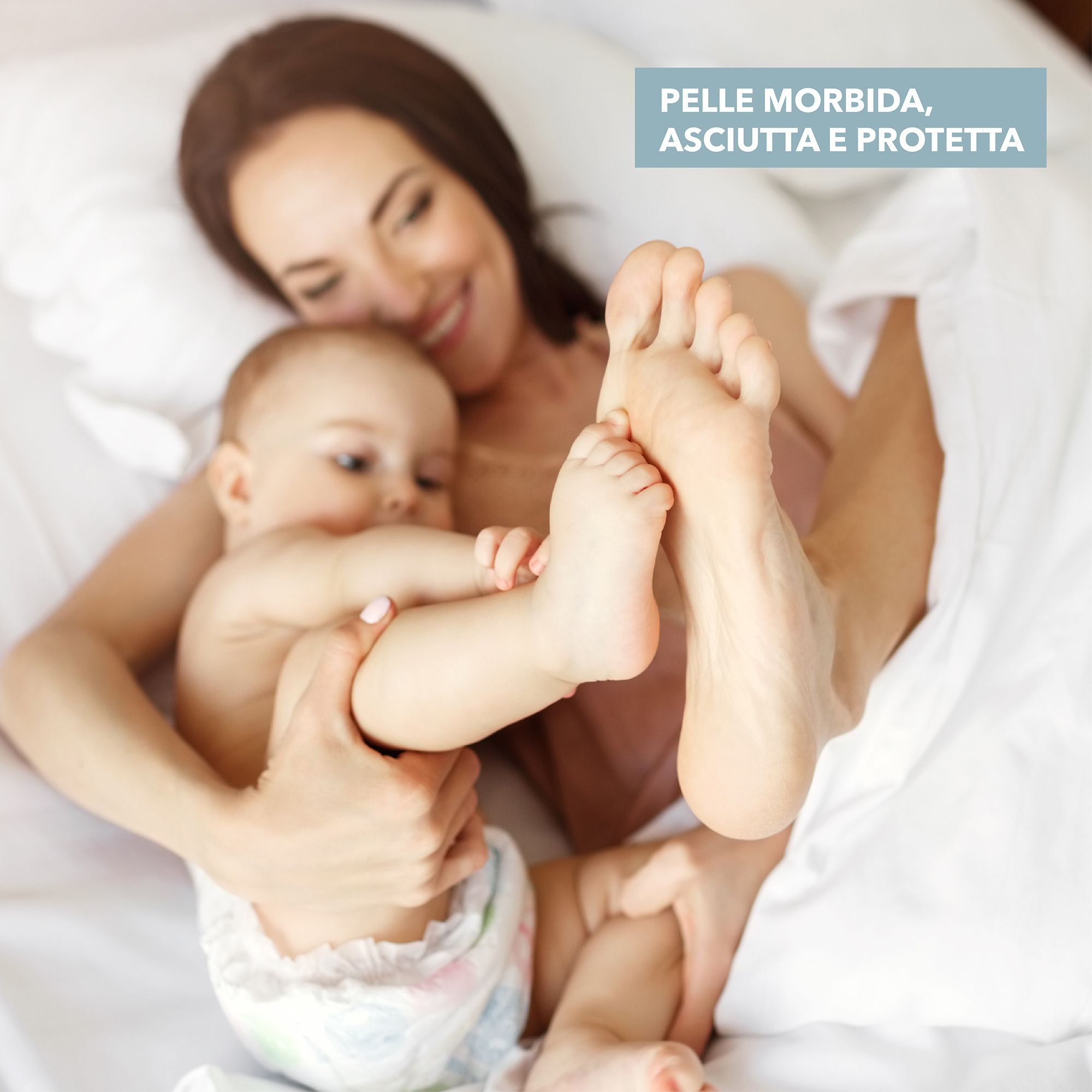 Mère et bébé au lit. Pieds de bébé en focus. Texte : Peau douce, sèche et protégée. Bébé porte une couche.