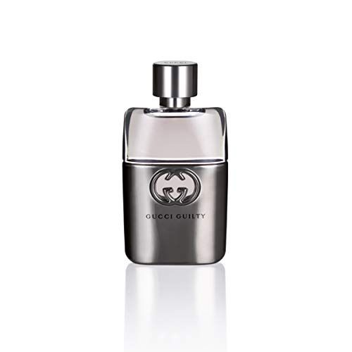 Flacon de Gucci Guilty Pour Homme. Flacon argenté avec logo. Fermeture métallique. Sur fond blanc.