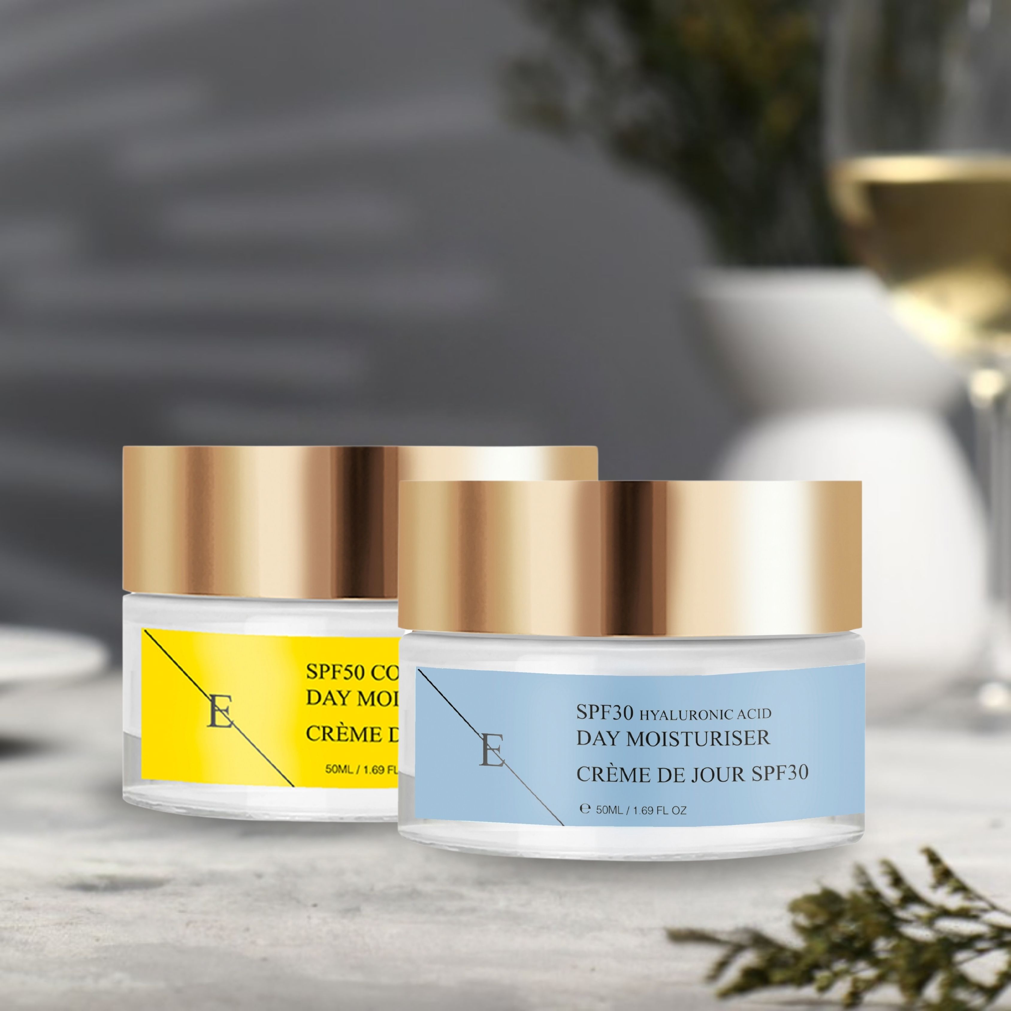Deux pots de crème de jour ErthSkin London sur une table. Pot jaune: SPF50 Collagène. Pot bleu: SPF30 Acide Hyaluronique. Couvercles dorés.