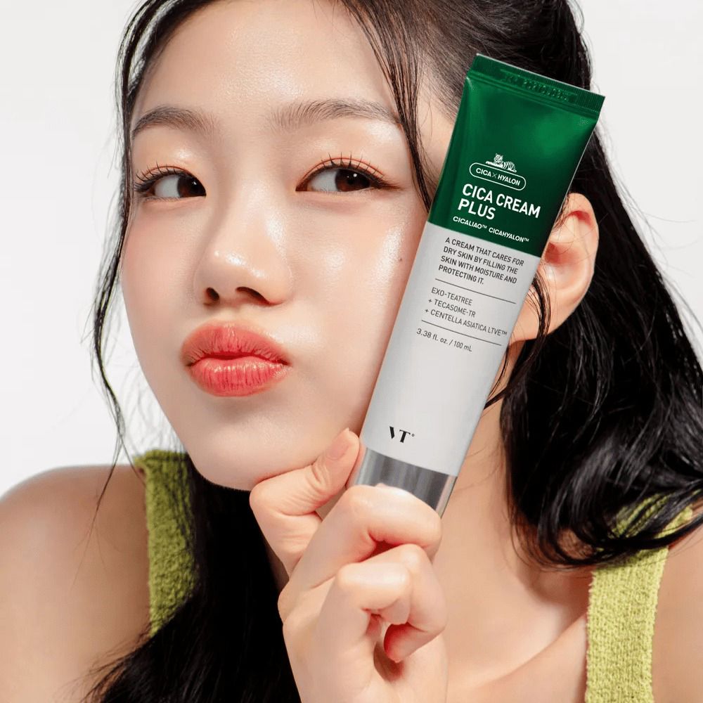 Tube de Cica Cream Plus. Tube vert et blanc avec bouchon vert. Inscription Cica Cream Plus. Femme tenant le tube.