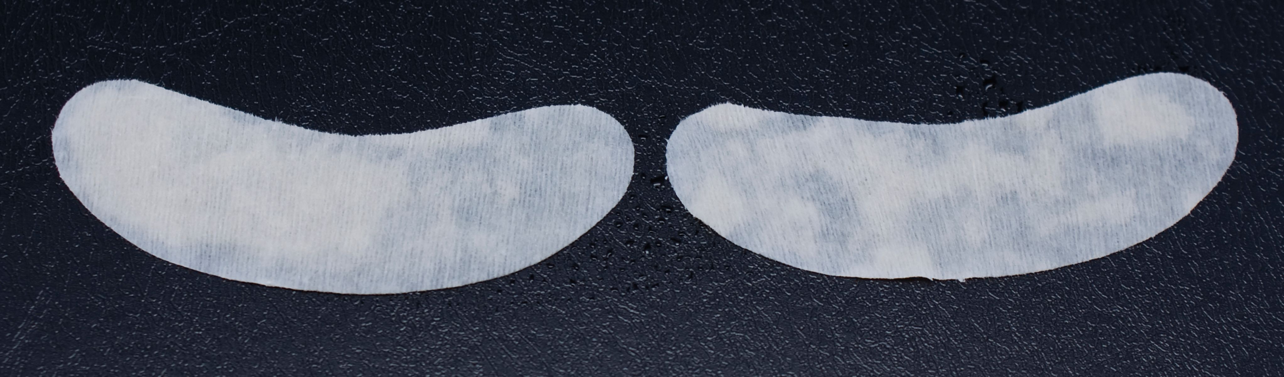 Twee witte oogpatches op donkere achtergrond. Halve maan vorm.