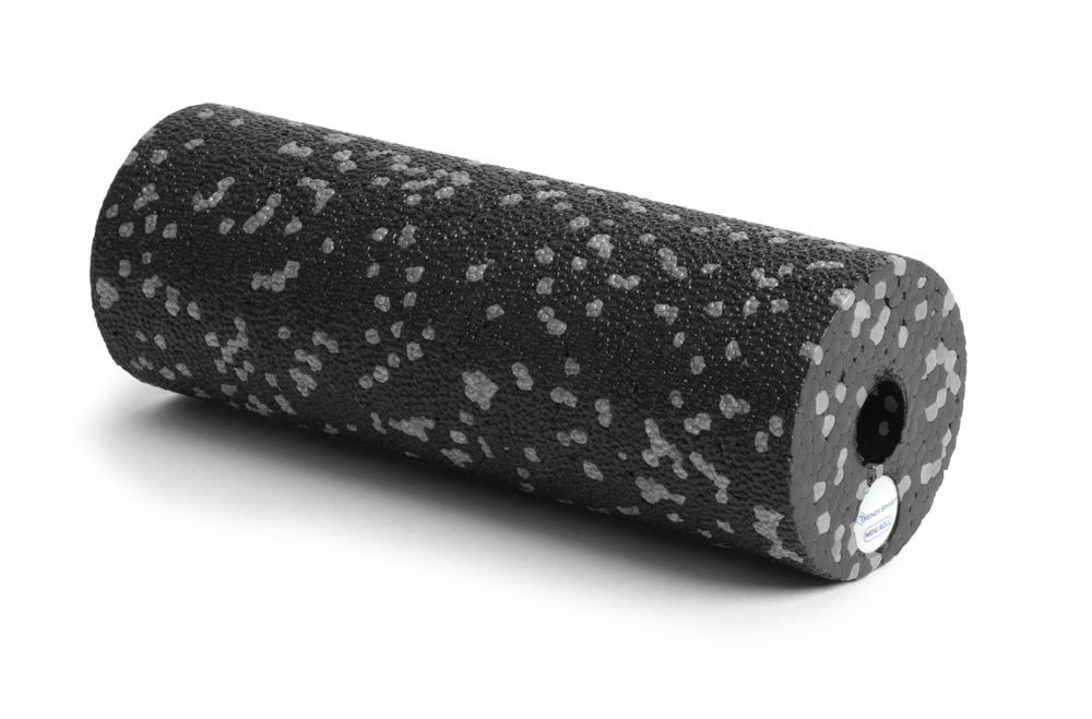 Rouleau de fascia noir avec des points gris. Forme cylindrique. Extrémités avec trou et autocollant.