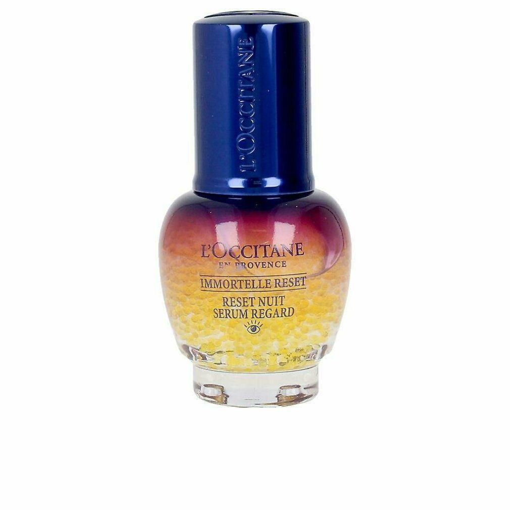 Flacon de sérum avec bouchon bleu. Inscriptions: L'Occitane, Immortelle Reset, Reset Nuit Serum Regard. Billes jaunes en bas.