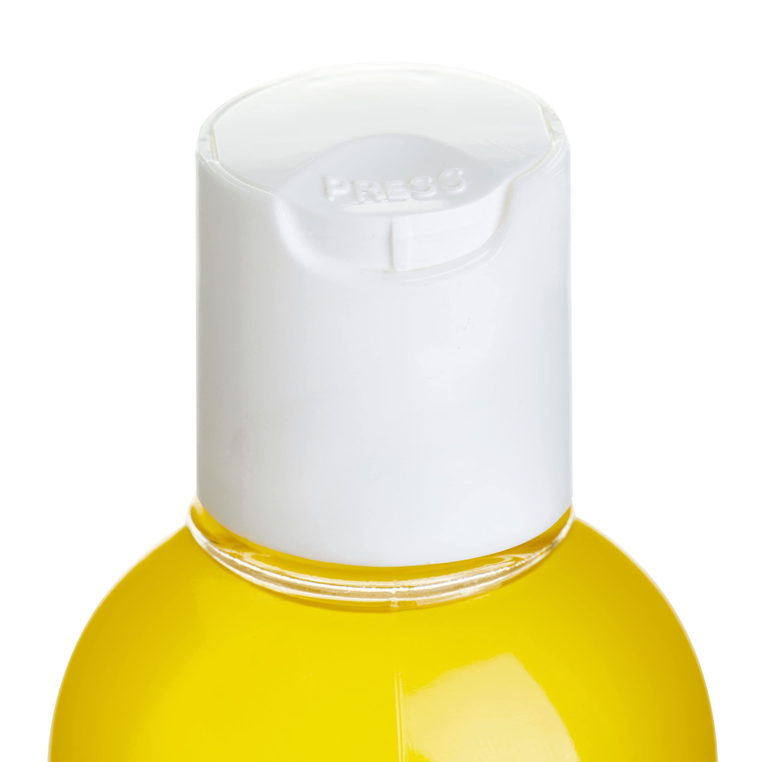 Fles Loovara Warm Up massageolie met geel etiket, omringd door oliespetters.