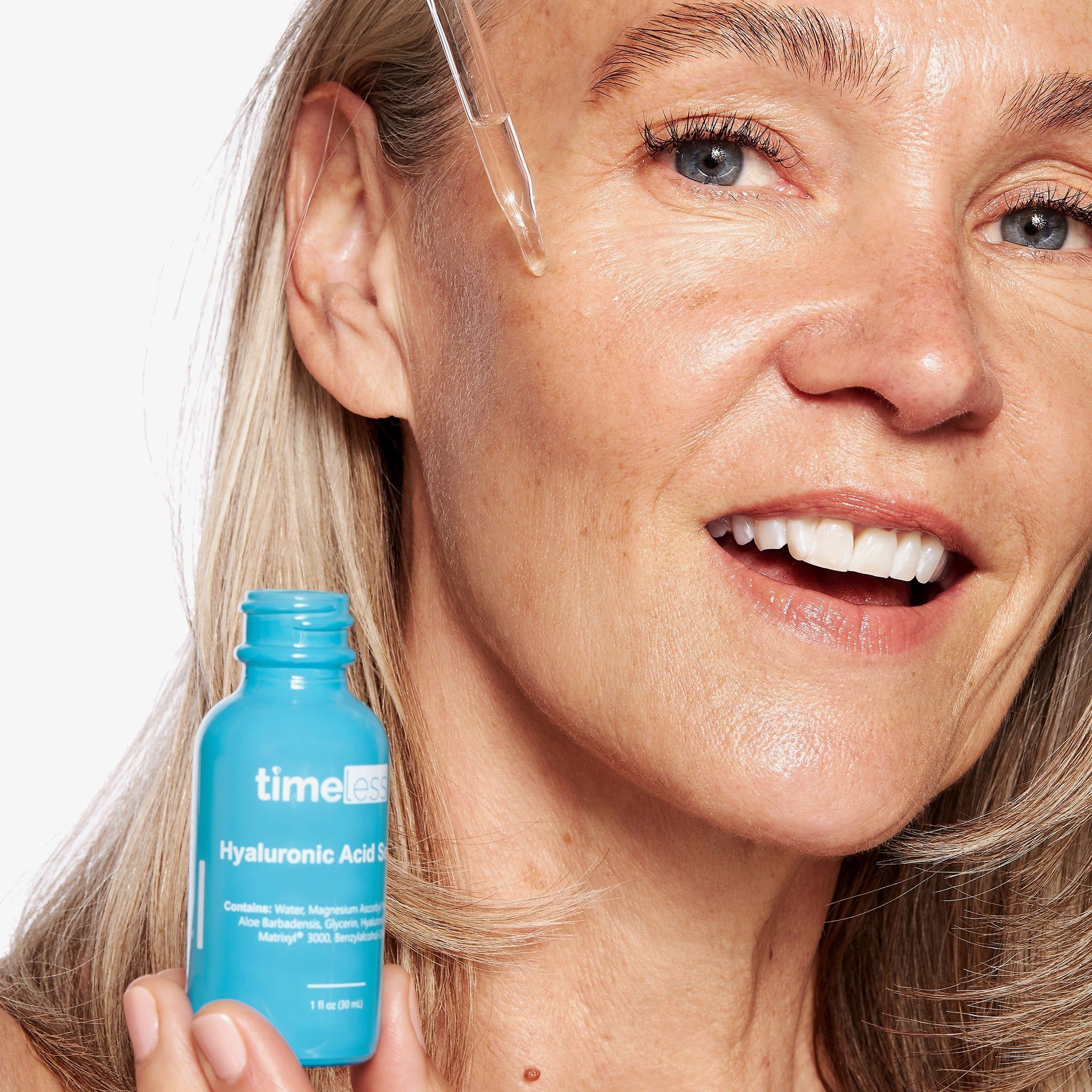 Vrouw met serumfles. Ze brengt het serum aan. Opschrift: Timeless Hyaluronic Acid Serum.