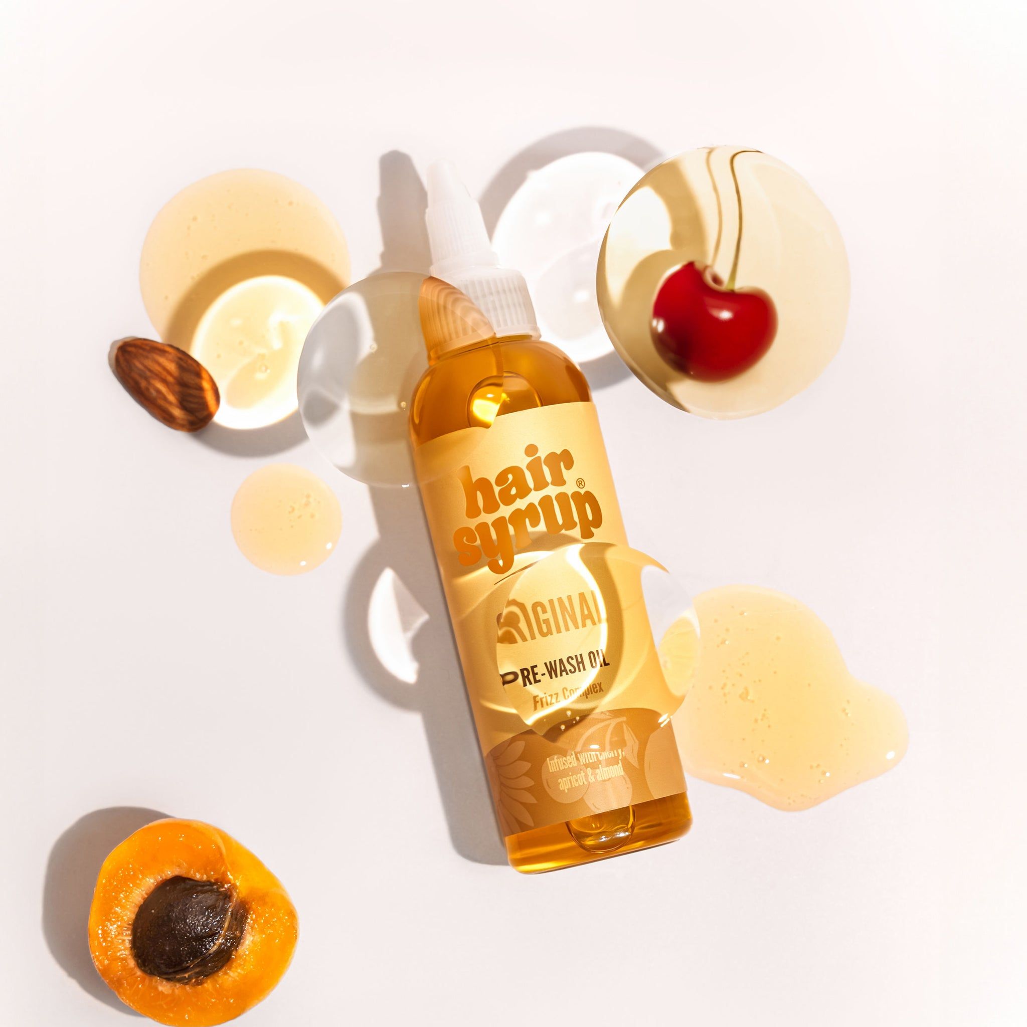 Fles Hair Syrup The Original met kers, abrikoos en amandel. Lichte achtergrond. Productlabel zichtbaar.