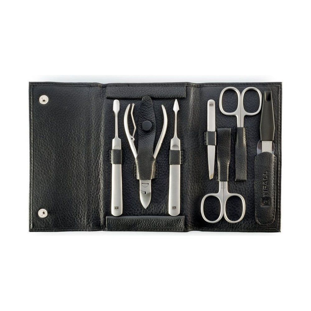 Trousse de manucure en cuir noir. Contient plusieurs outils argentés : ciseaux à ongles, lime, pince à épiler, etc. Ouvert sur fond blanc.
