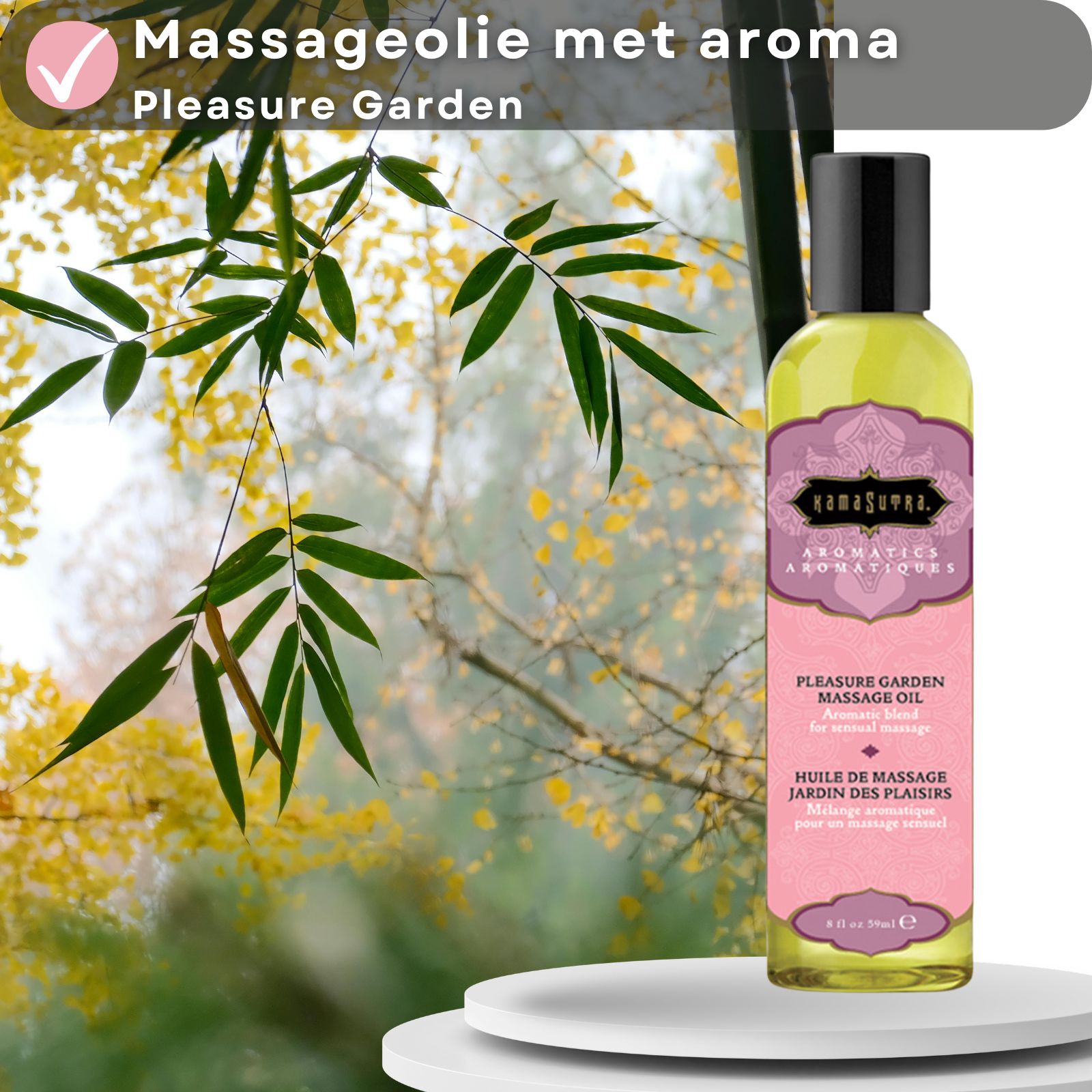 Kamasutra massageolie met aroma Pleasure Garden. Fles op wit oppervlak, achtergrond met bladeren en bamboe.