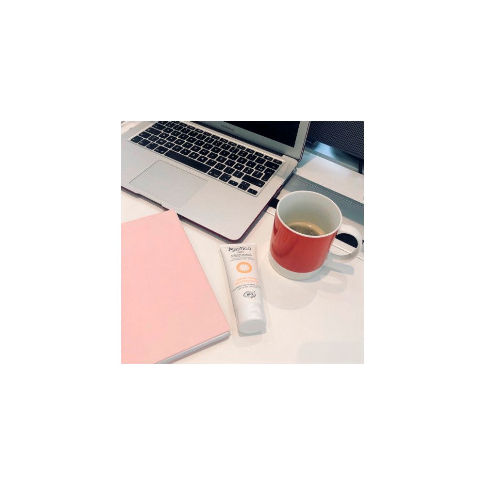 Tube de crème pour les mains, blanc, avec logo Marilou Bio et texte. Sur un bureau avec ordinateur portable et tasse.