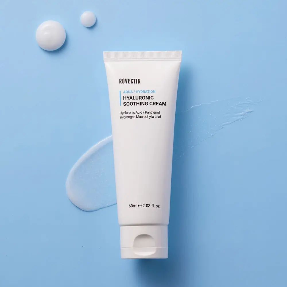 Tube blanche avec texte bleu sur fond bleu. Texte: Rovectin, Aqua/Hydration, Hyaluronic Soothing Cream. 60ml/2.03 fl. oz.