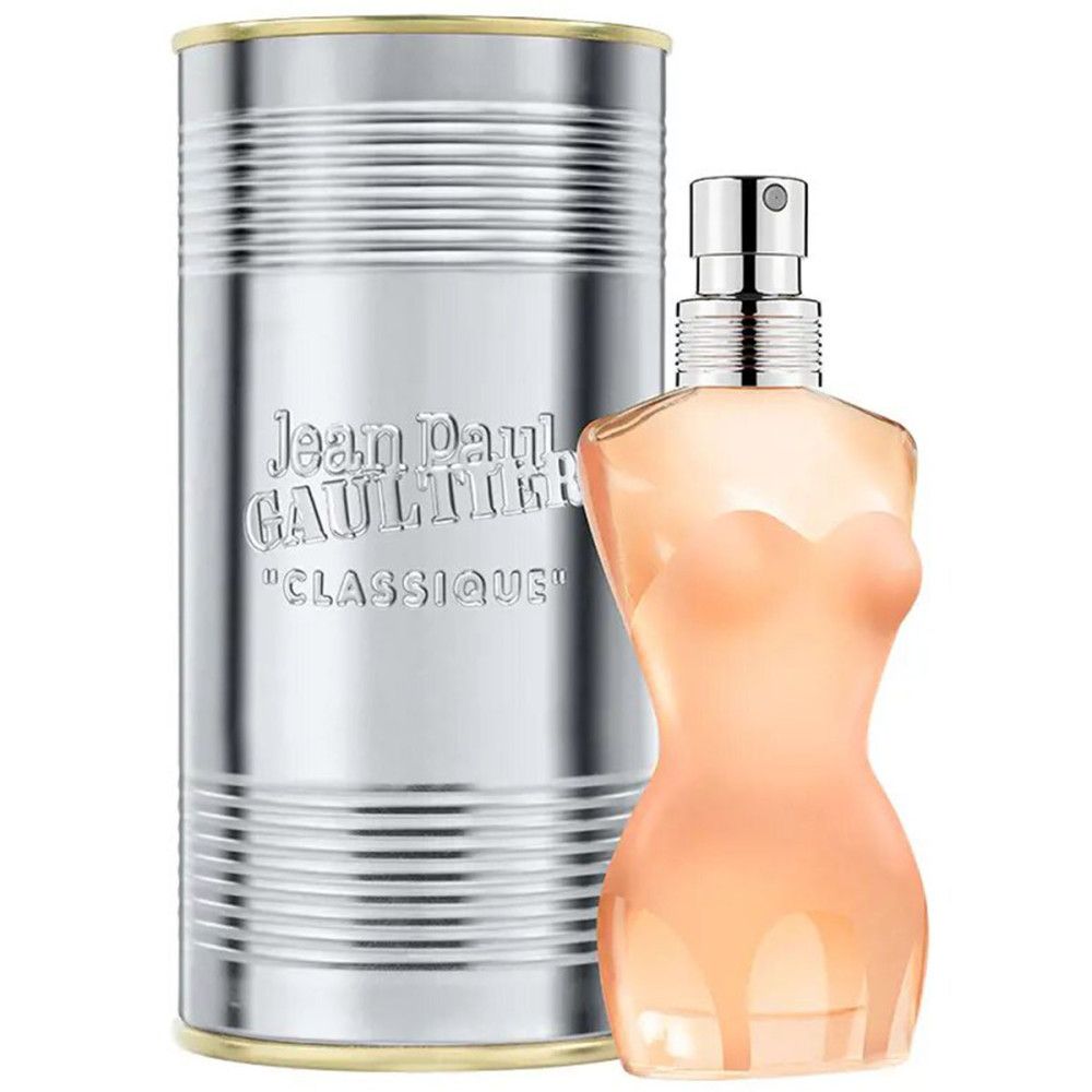 Flacon de parfum en forme de corps féminin à côté d'une boîte argentée. Inscription : Jean Paul Gaultier, Classique. Vaporisateur argenté.