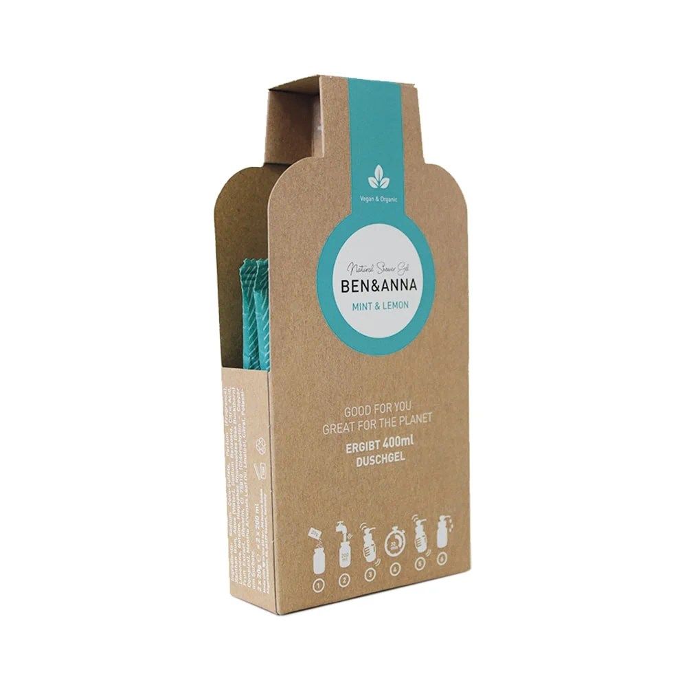 Emballage marron avec étiquette turquoise. Inscription : Ben & Anna, Mint & Lemon, gel douche. Contient une bouteille et une brosse.