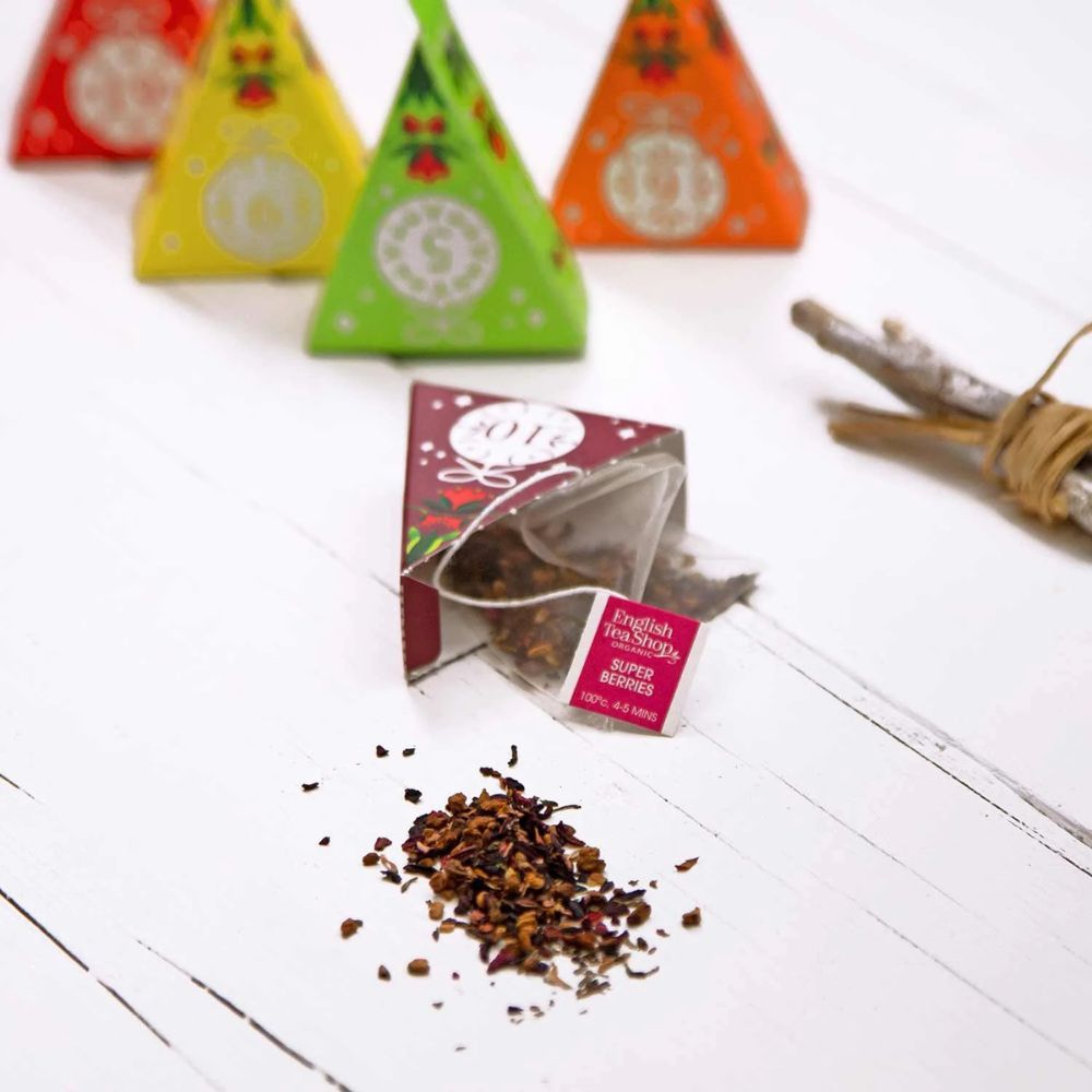Piramidezakjes met thee op wit hout. Open zakje met losse thee. English Tea Shop Super Berries.