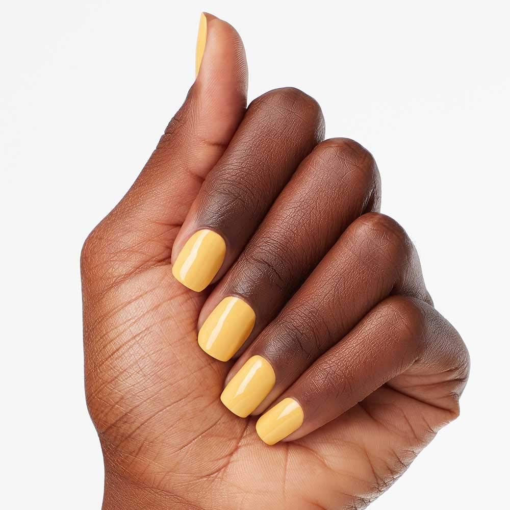 Hand met gele nagellak op de nagels. Close-up.