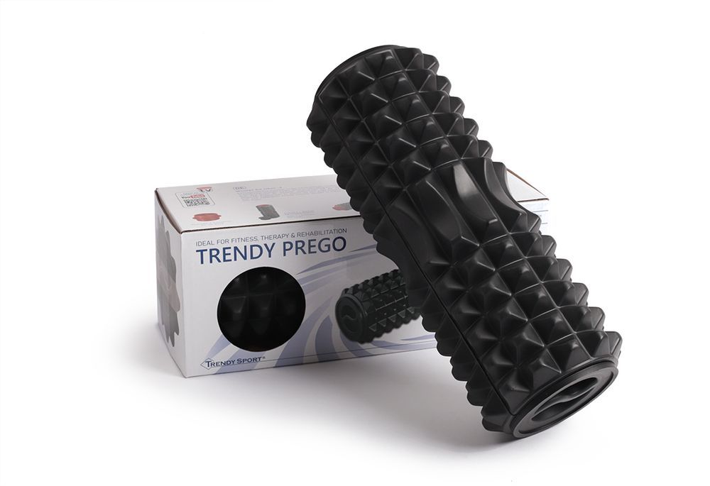 Rouleau de massage noir à côté de l'emballage. Emballage avec image du produit et texte Trendy Prego®.