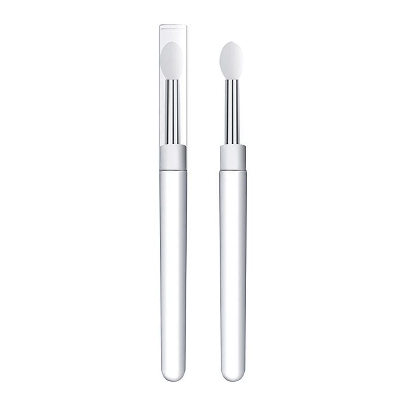 Deux applicateurs à manche transparent et embout en silicone blanc, dont un avec capuchon de protection.
