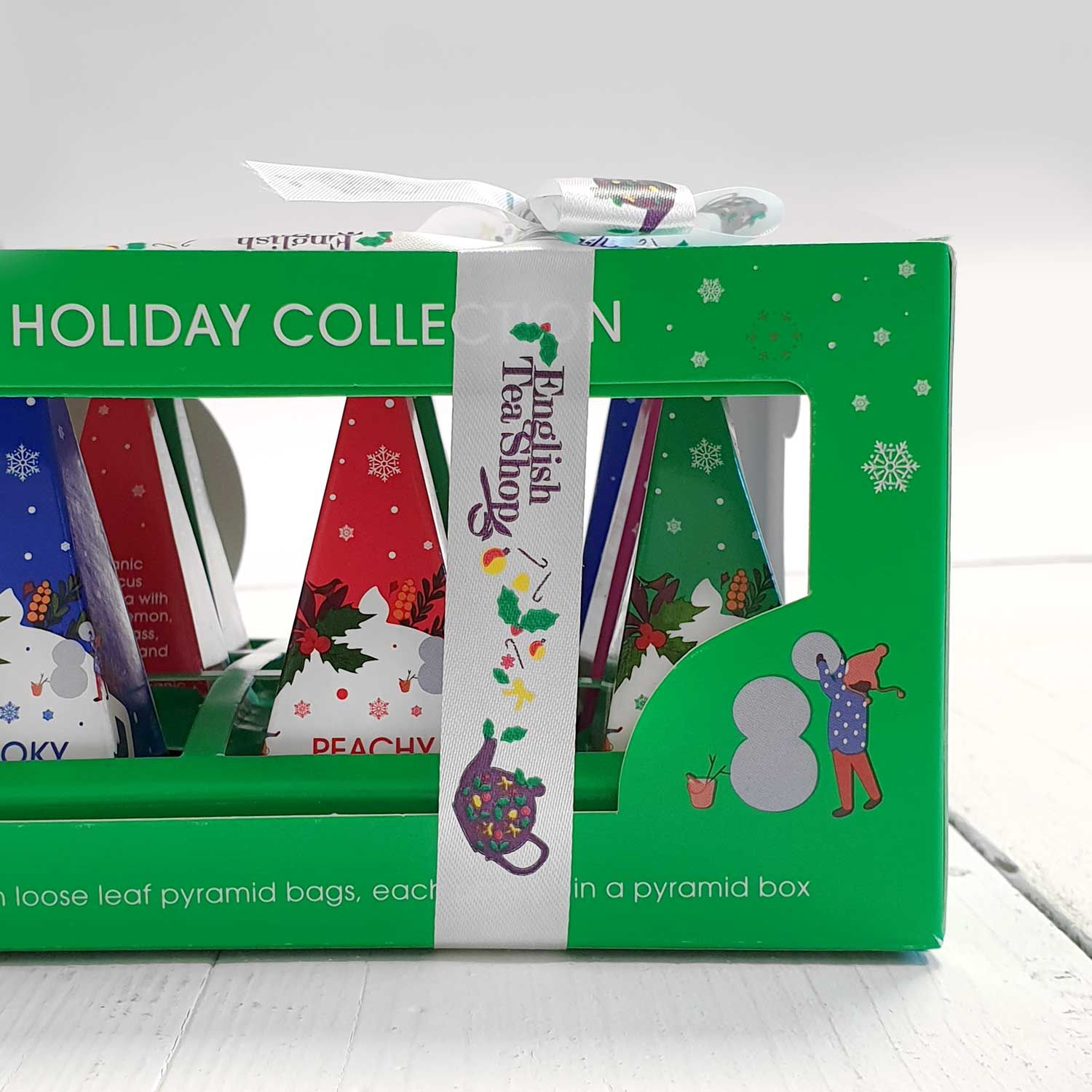 Groene doos met piramidevormige theezakjes. Opschrift: English Tea Shop, Holiday Collection. Met lint.