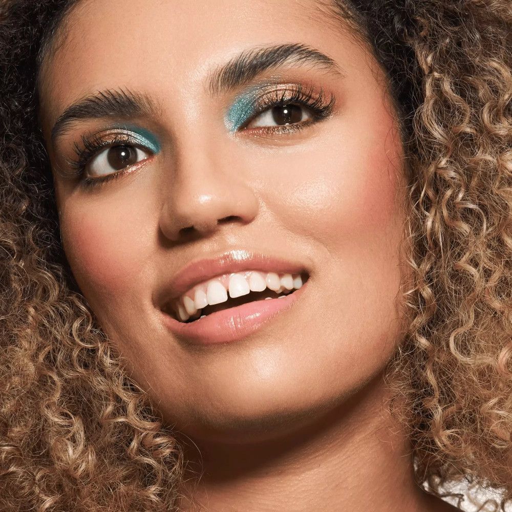 Portret van een vrouw met make-up. Blauwe oogschaduw, roze lippenstift.