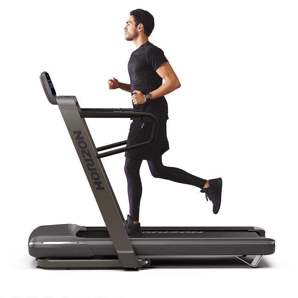 Homme courant sur un tapis roulant. Tapis roulant avec logo Horizon. L'homme porte des vêtements de sport.