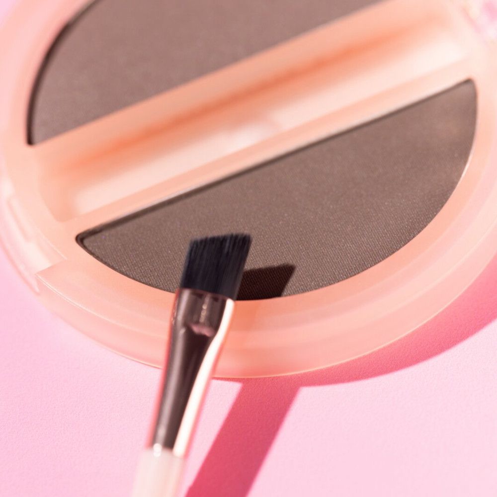 Gros plan du duo-set pour sourcils avec pinceau. Boîtier rose, deux teintes.