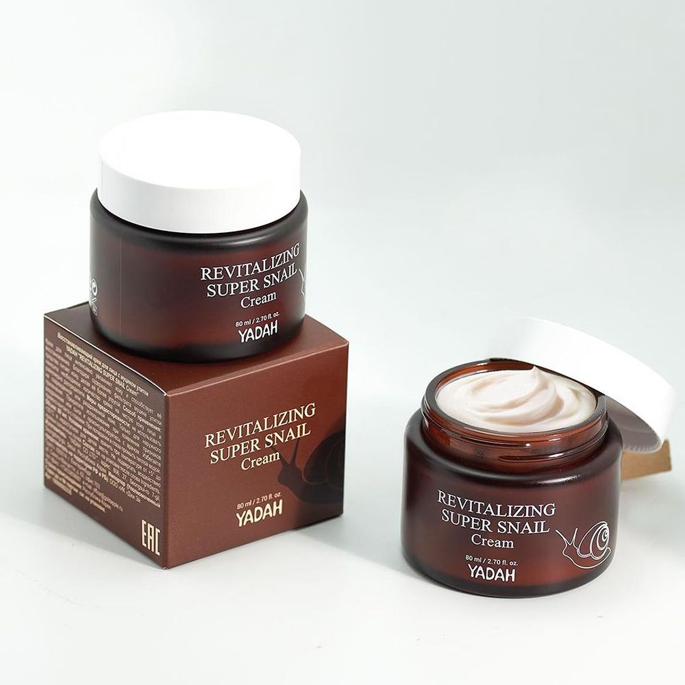 Deux pots de crème bruns avec couvercles blancs et une boîte. Inscription: Revitalizing Super Snail Cream, YADAH. Illustration d'escargot.