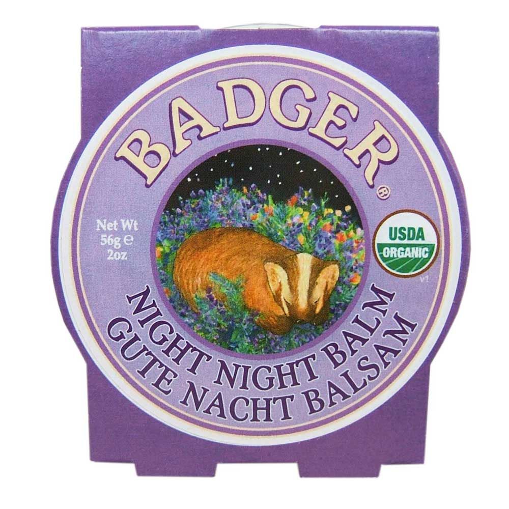 Paarse verpakking met ronde sticker. Opschrift "BADGER NIGHT NIGHT BALM". Afbeelding van een das in een cirkel. USDA Organic zegel.