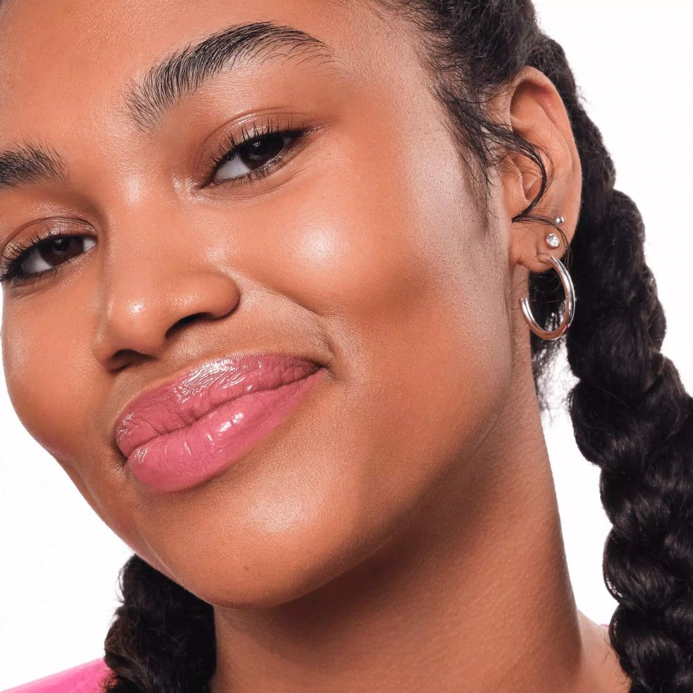 Portret van een vrouw met roze lipgloss. Donkere huid, gevlochten haar. Close-up.