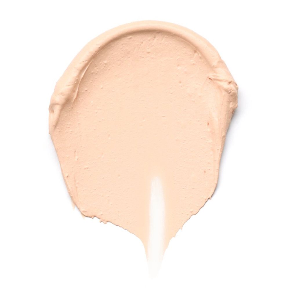 Échantillon de fond de teint clair et crémeux sur fond blanc. Texture visible.