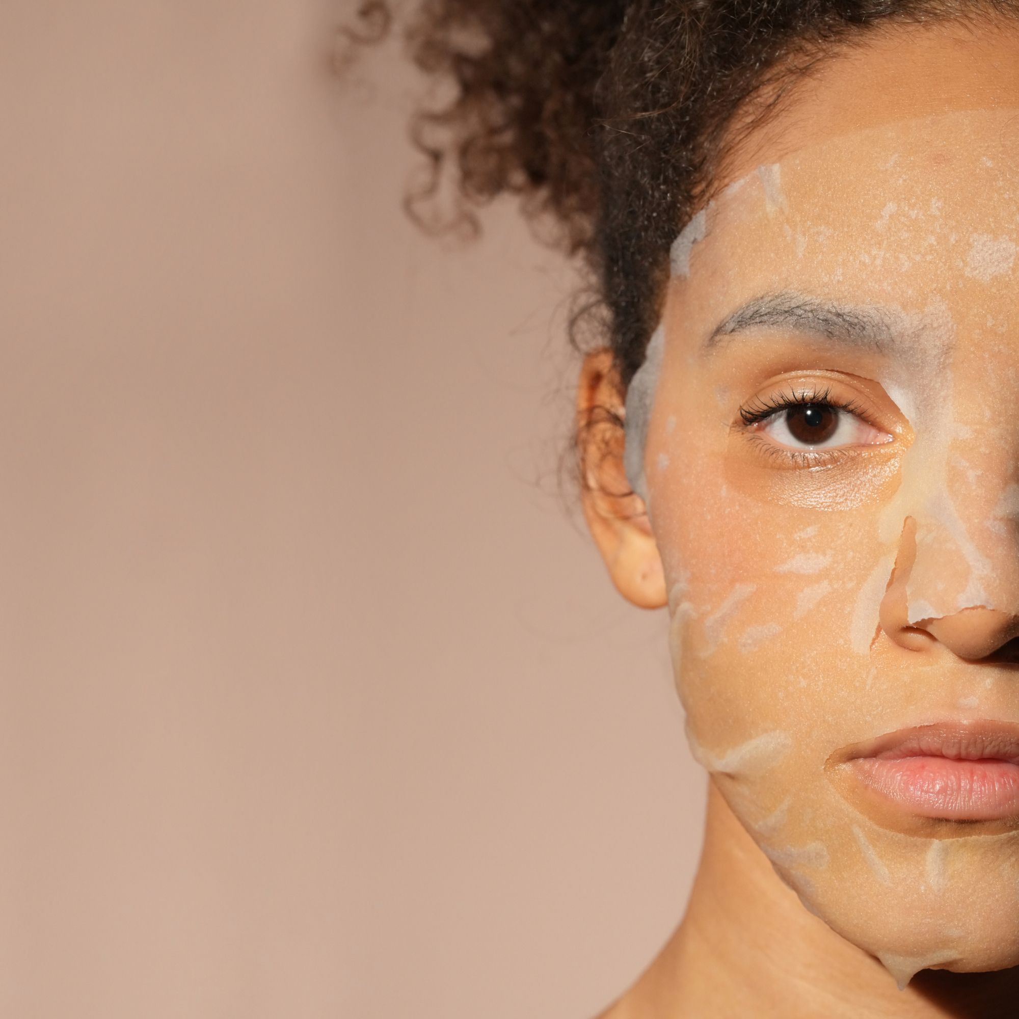 Gros plan d'une femme portant un masque facial hydratant en tissu à base de collagène.