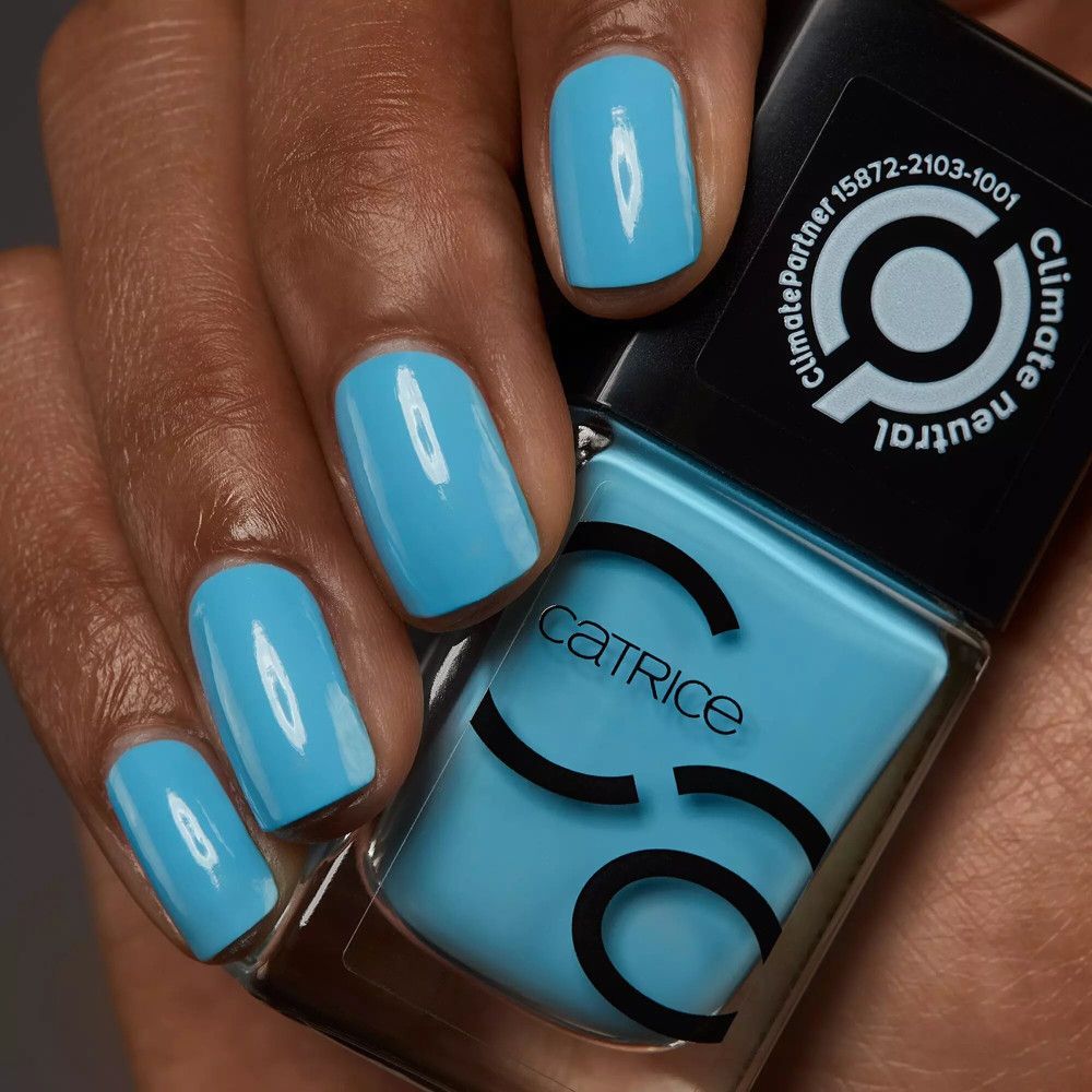 Vernis à ongles bleu clair et ongles vernis. Flacon Catrice. Logo Climate Partner.