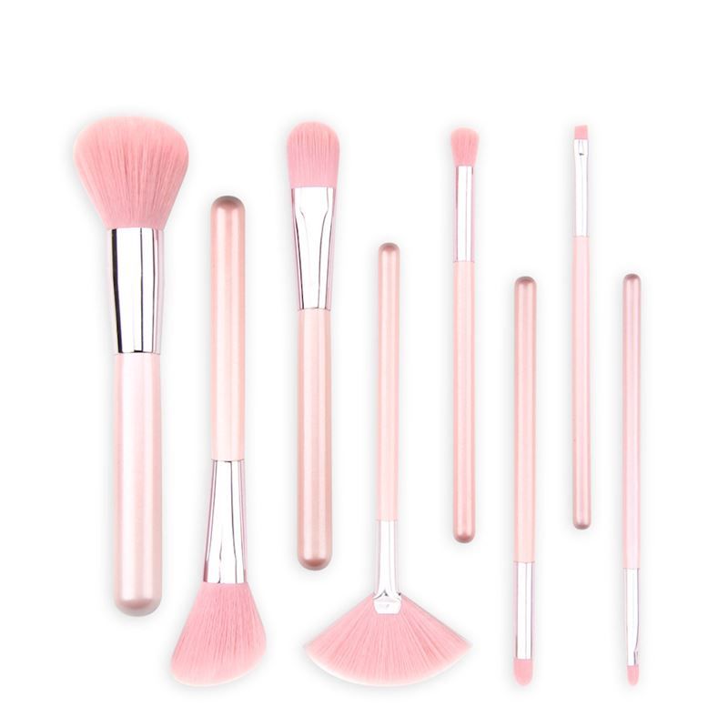 Een set van acht roze make-upkwasten met zilveren accenten, op een witte achtergrond.