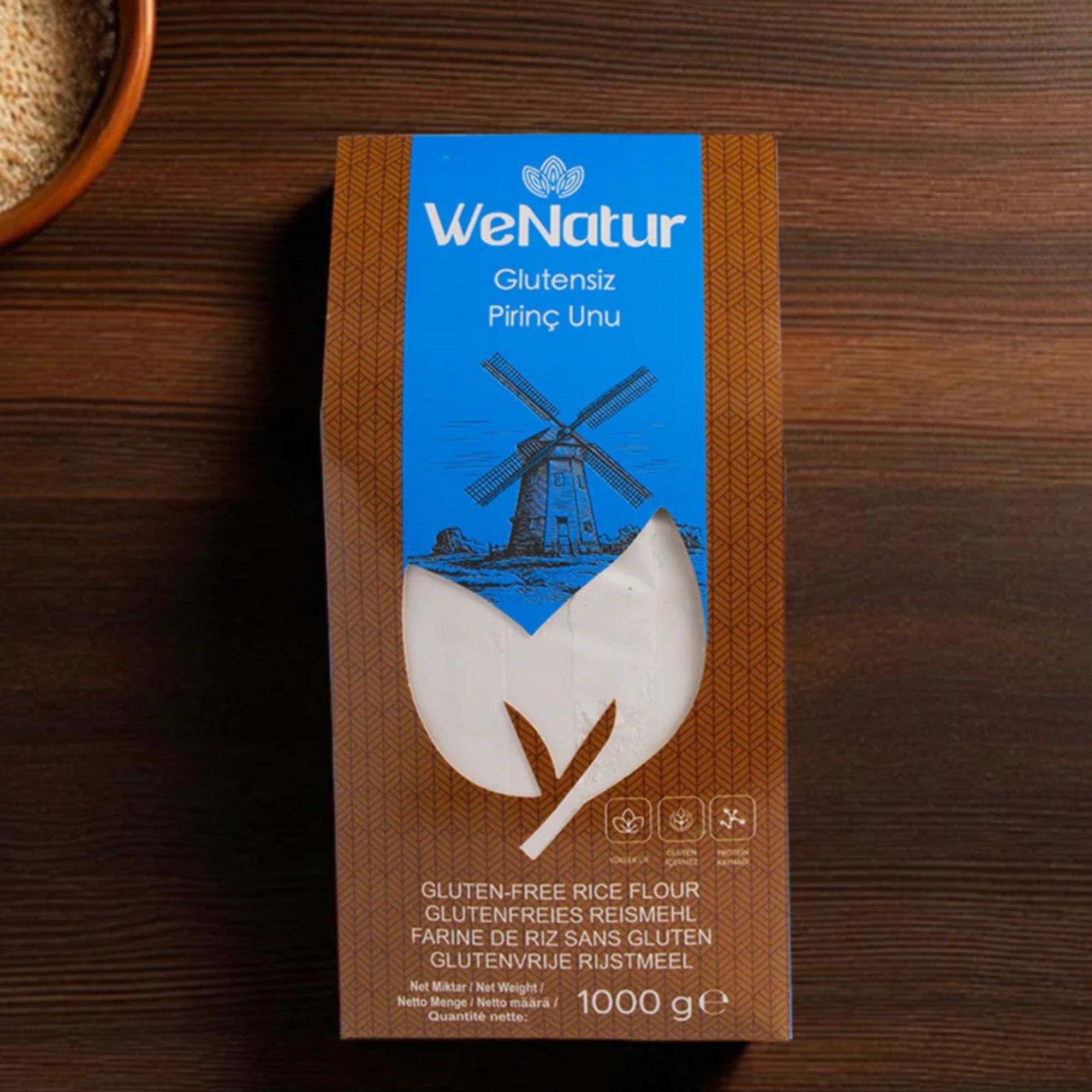 WeNatur glutenvrije rijstmeel, 1000g verpakking op een houten tafel.