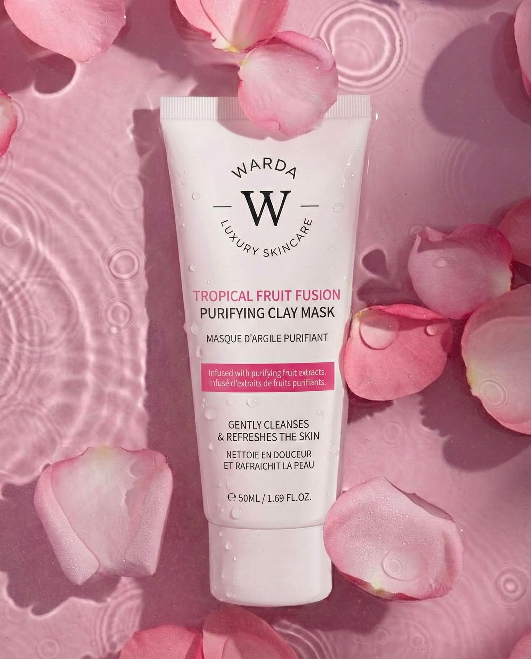 Warda Luxury Skincare Tropical Fruit Fusion kleimasker. Witte tube met roze tekst. Omringd door roze bloemblaadjes.