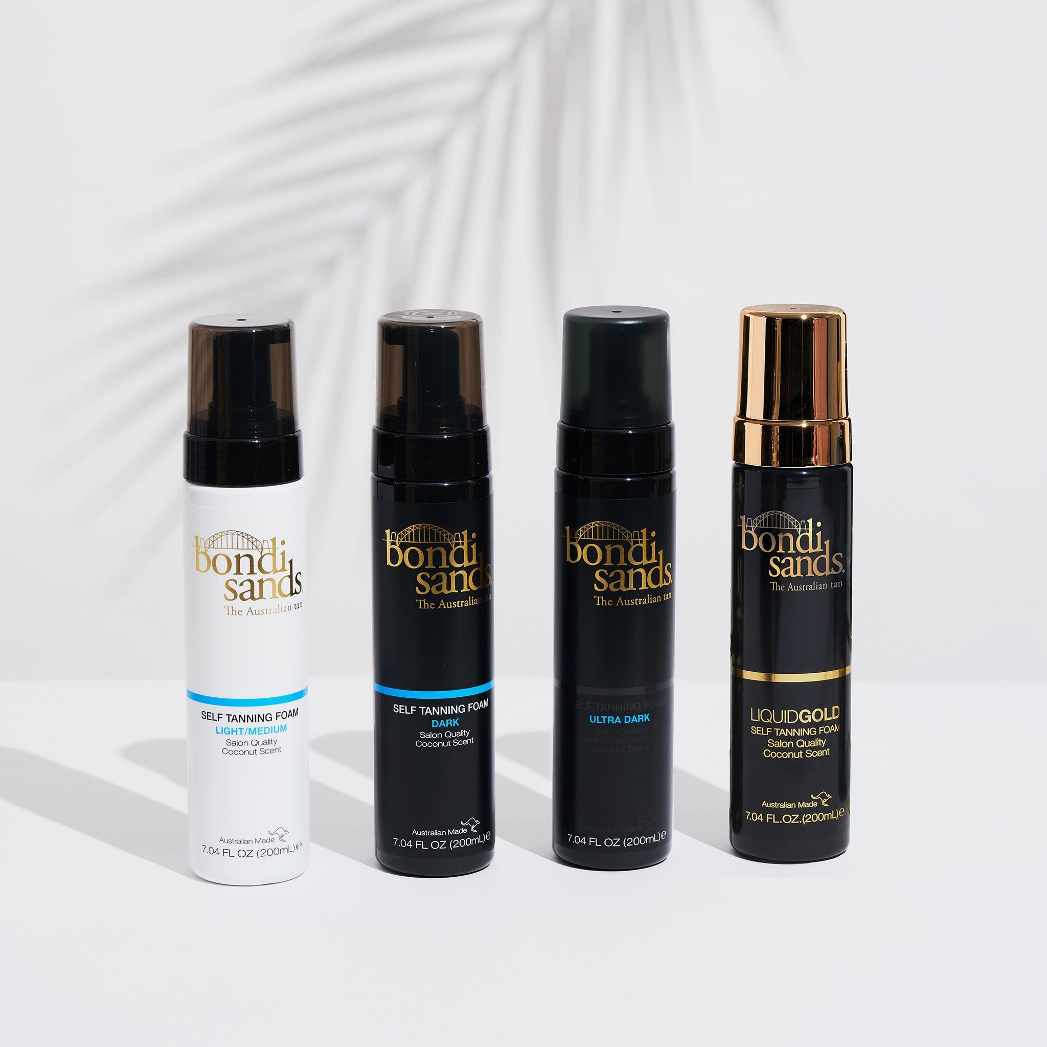 Vier flessen zelfbruiningsschuim. Opschriften: Bondi Sands, Light Medium, Dark, Ultra Dark, Liquid Gold. Zwarte en witte flessen.