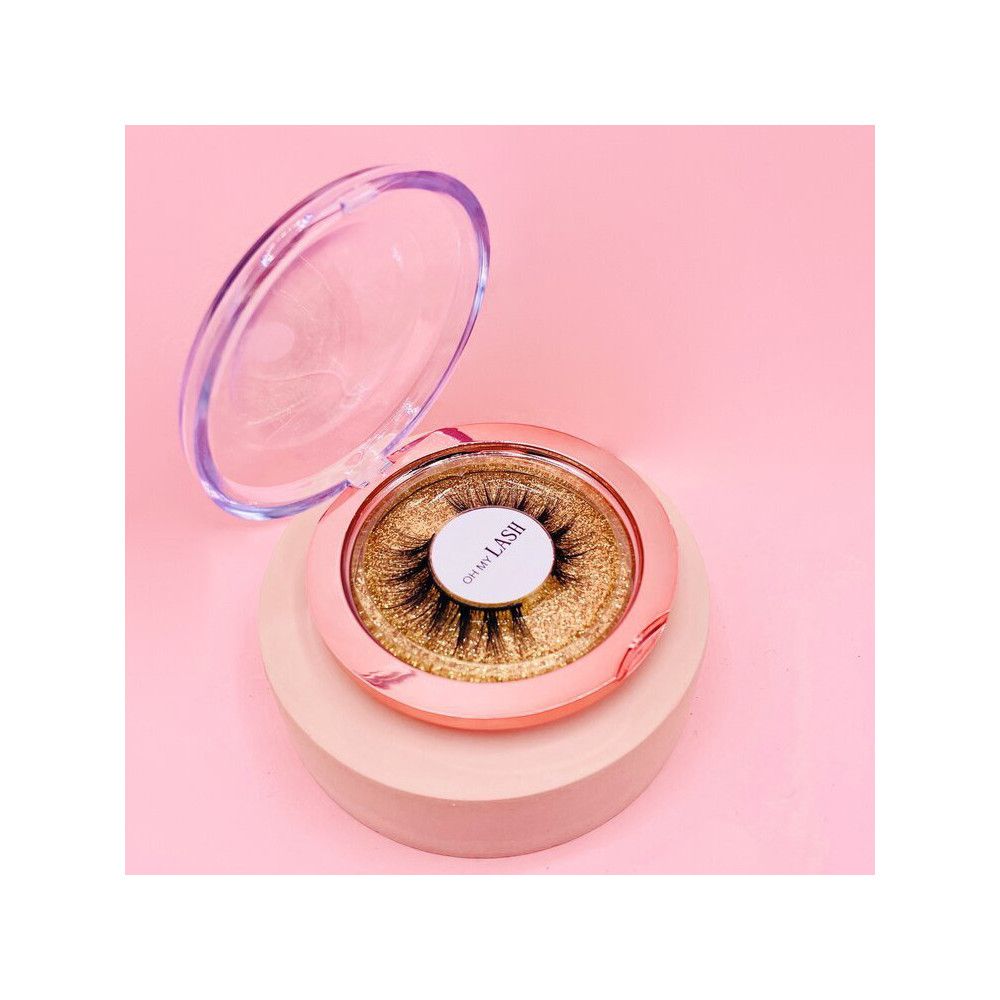 Faux cils dans un emballage rond rose avec couvercle transparent. Inscription : Oh My Lash.
