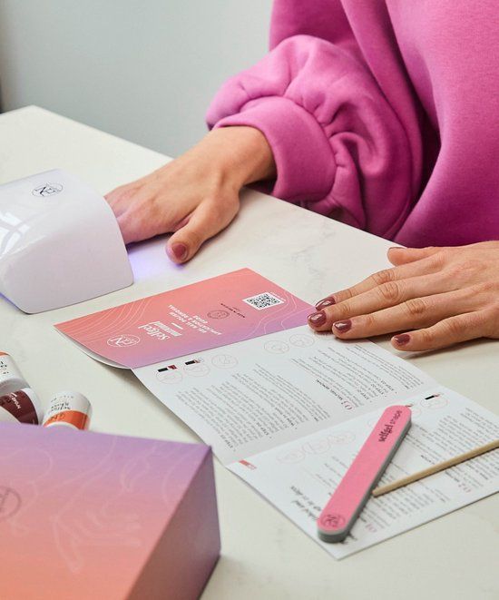 Personne avec manucure. Lampe UV, brochure et lime. Inscription: selfgel manual. Logo PN.