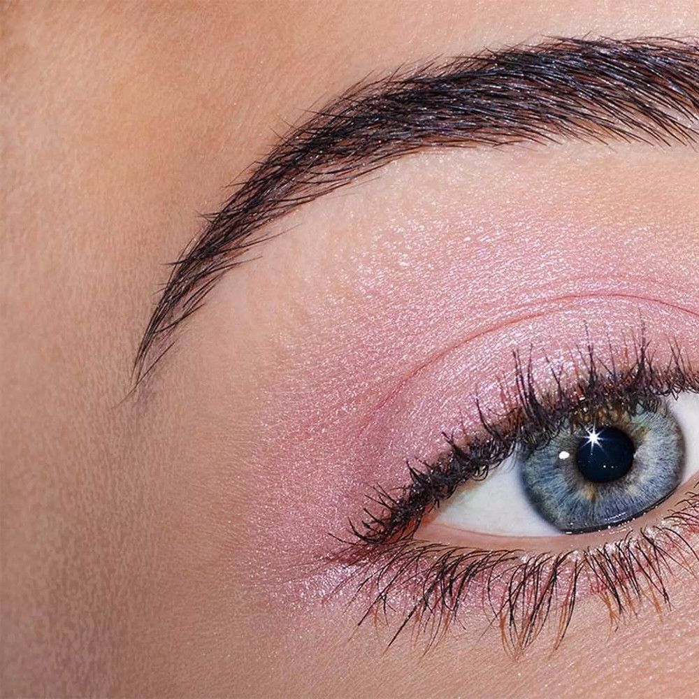 Œil avec fard à paupières rose. Couleur des yeux bleue. Sourcil brun.